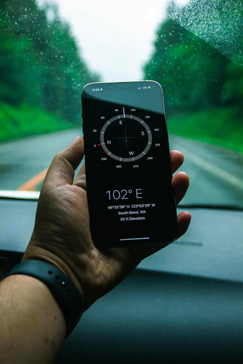 Hand holding smartphone displaying compass and coordinates
