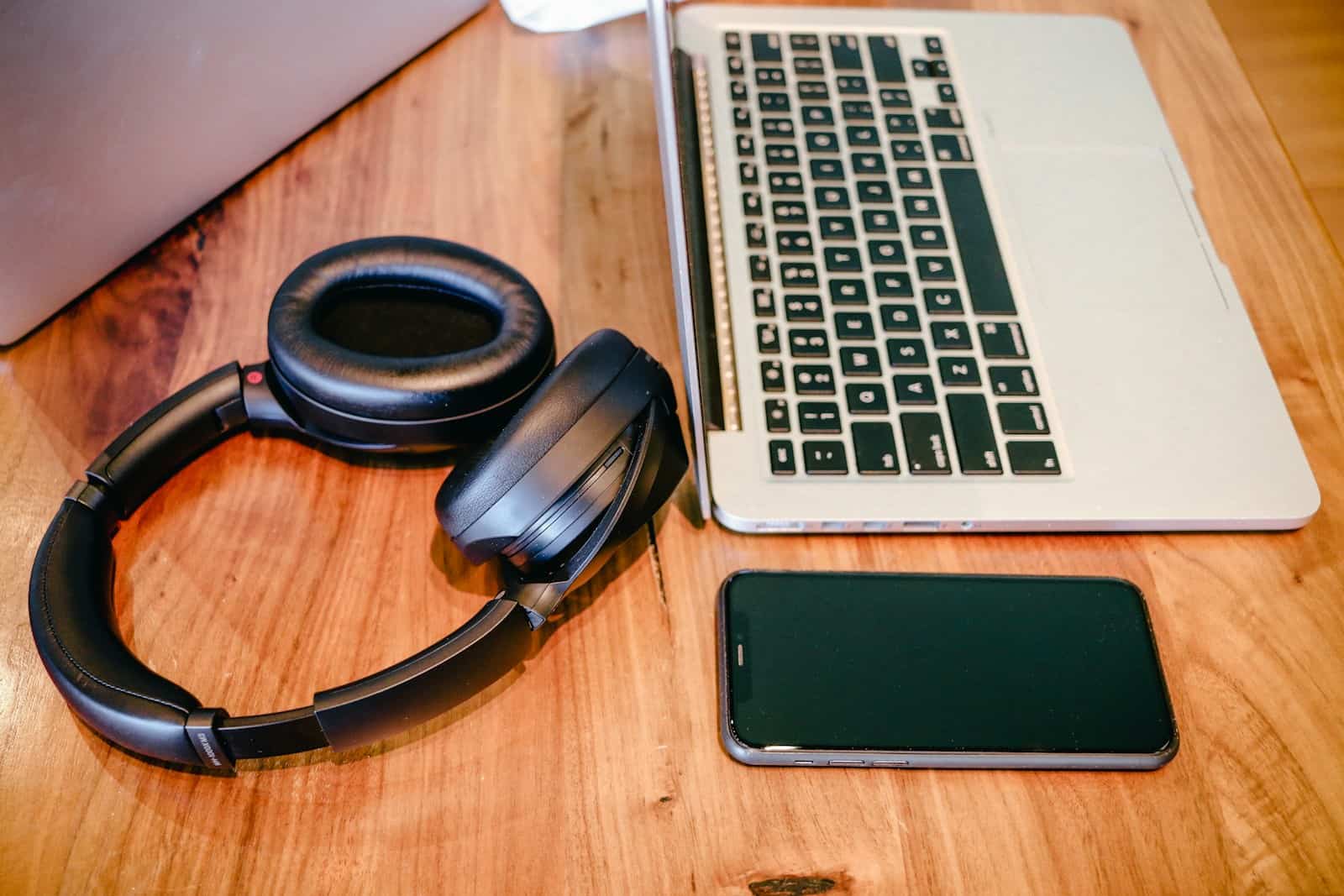 a laptop and headphones on a wooden table