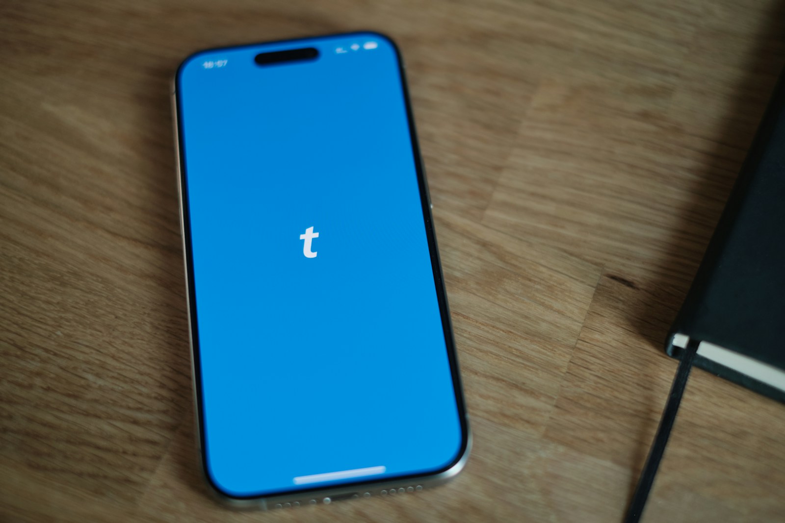 A blue iPhone sitting on top of a wooden table