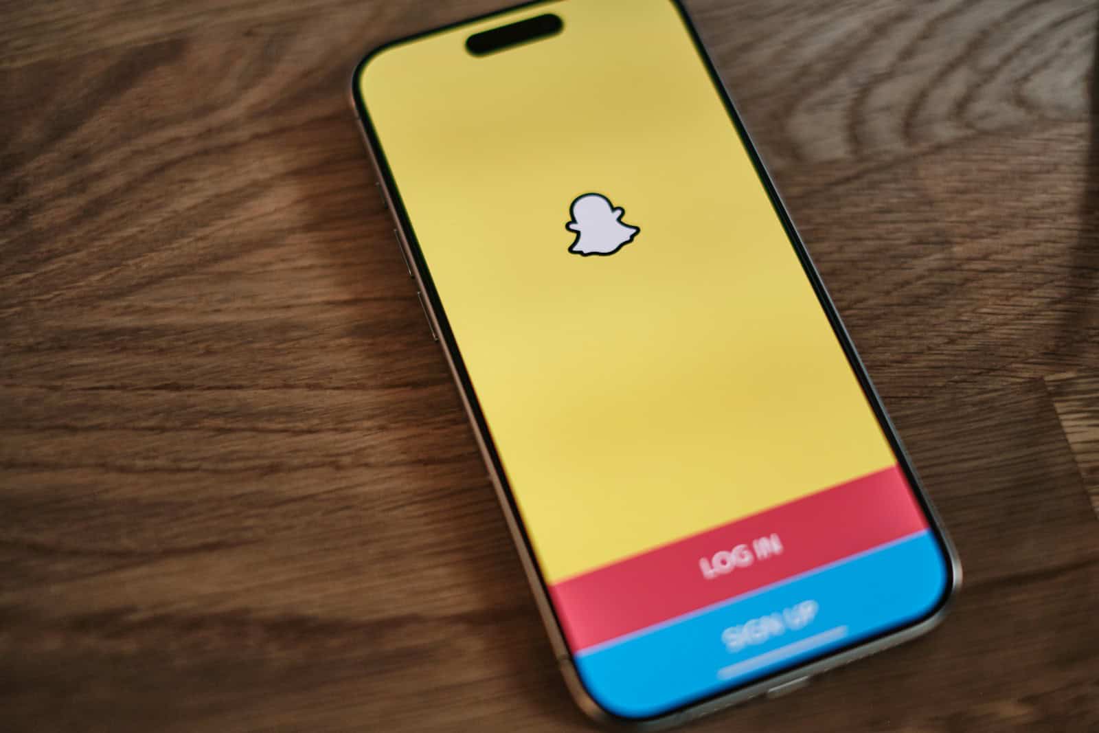A yellow and blue iPhone sitting on top of a wooden table