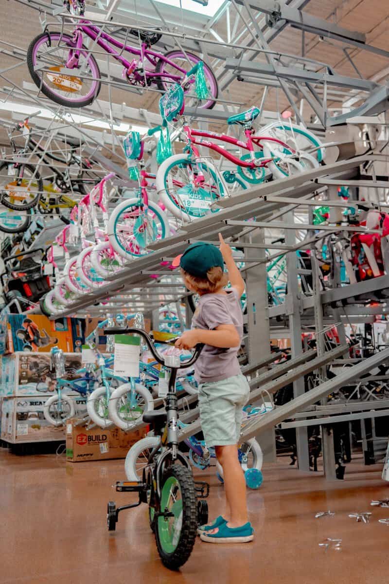 A young boy standing next to a bike in a store